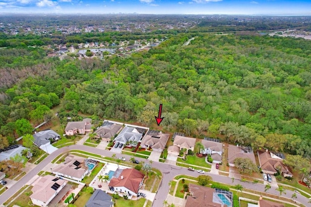 birds eye view of property featuring a wooded view and a residential view