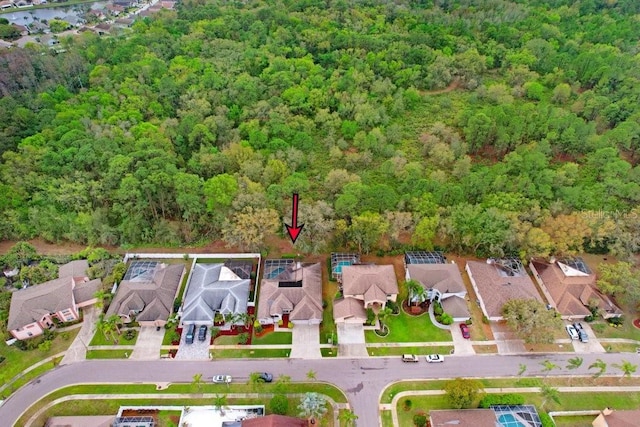 drone / aerial view featuring a residential view and a wooded view