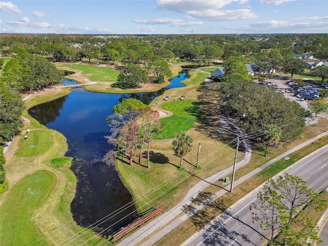 drone / aerial view with golf course view and a water view