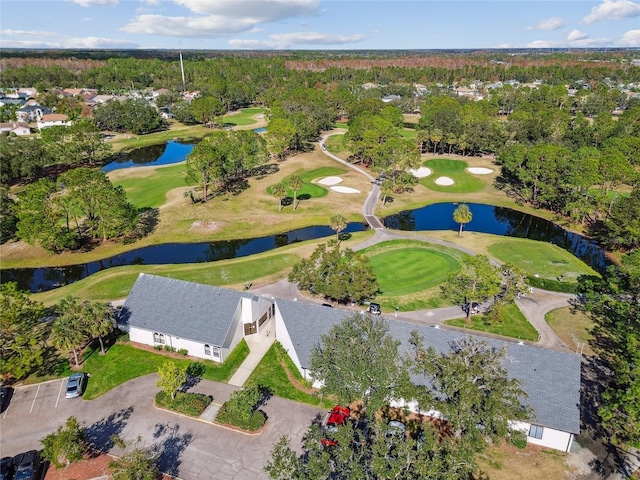 drone / aerial view with golf course view and a water view