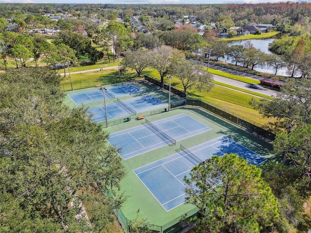 view of sport court with a water view and fence