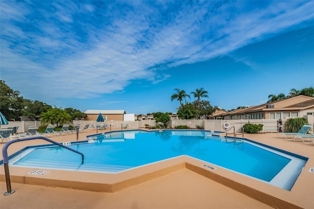 pool with a patio area and fence