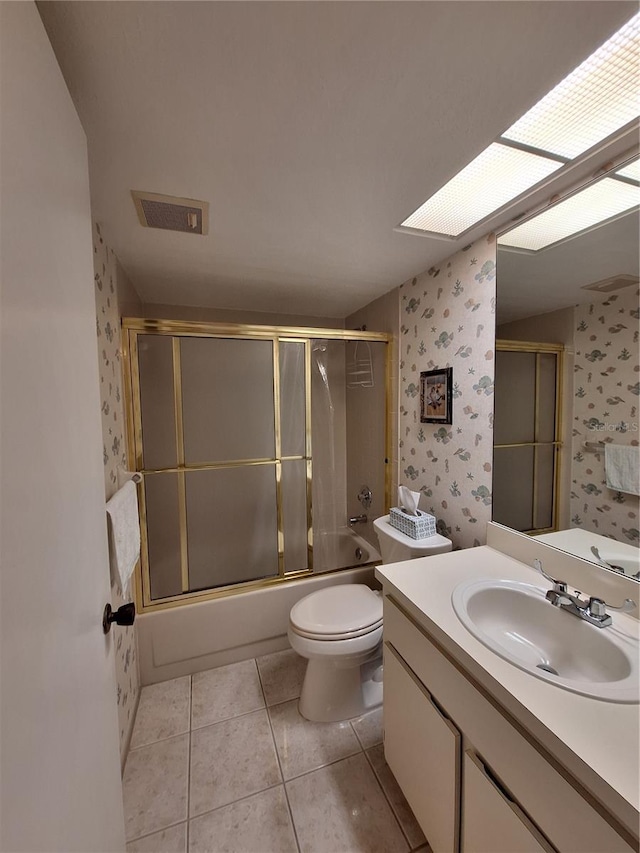 full bath featuring visible vents, wallpapered walls, bath / shower combo with glass door, tile patterned floors, and vanity