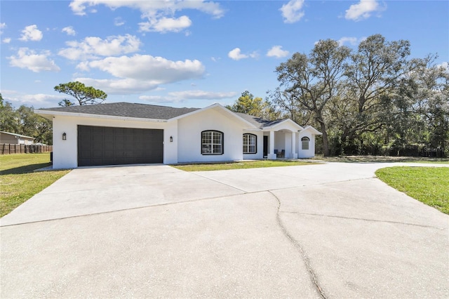 view of front facade featuring a garage, stucco siding, driveway, and a front lawn