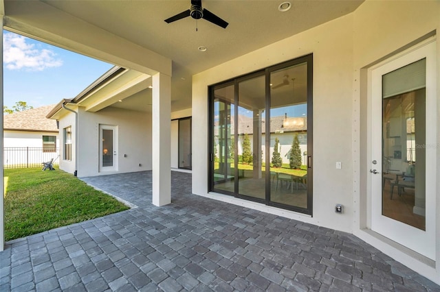 view of patio / terrace with ceiling fan and fence