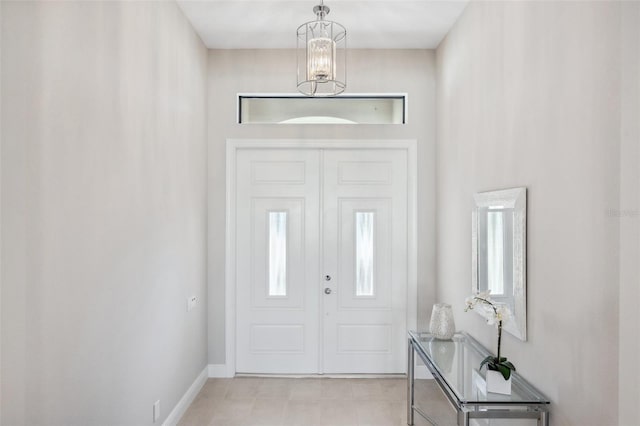 foyer entrance with baseboards and a chandelier