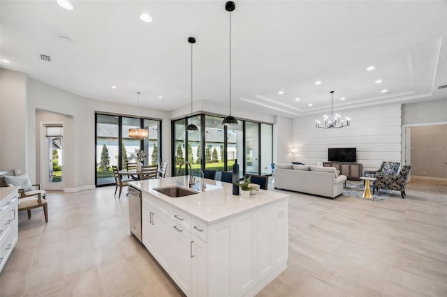 kitchen featuring visible vents, a sink, a chandelier, a tray ceiling, and stainless steel dishwasher