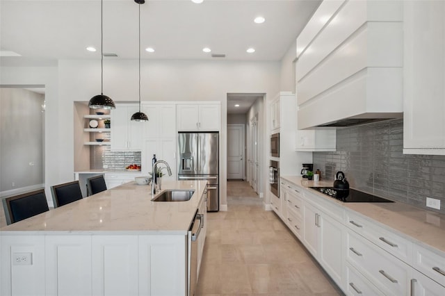 kitchen with premium range hood, an island with sink, a sink, appliances with stainless steel finishes, and white cabinetry