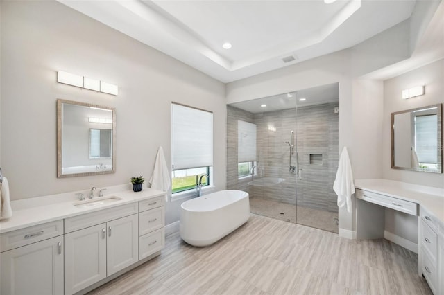 bathroom with visible vents, a stall shower, vanity, and a freestanding tub