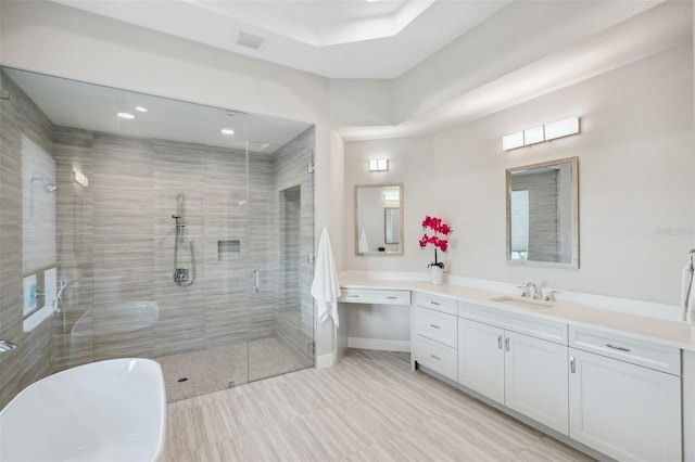 full bath with visible vents, a shower stall, baseboards, a freestanding bath, and vanity