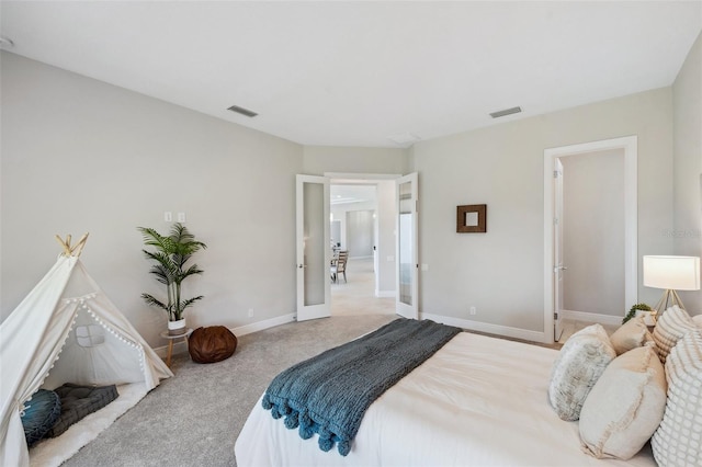 carpeted bedroom featuring french doors, visible vents, and baseboards