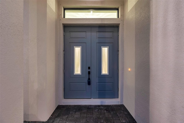 doorway to property featuring stucco siding