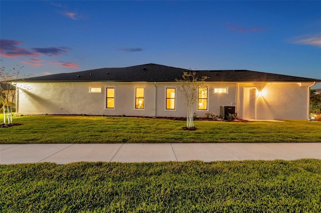 view of front of home featuring stucco siding and a yard