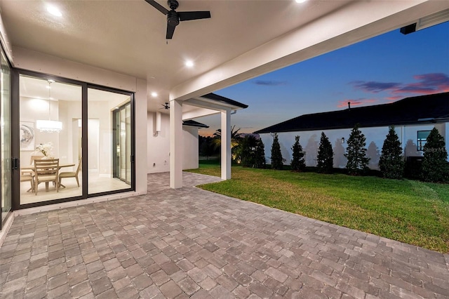 patio terrace at dusk with a lawn and ceiling fan