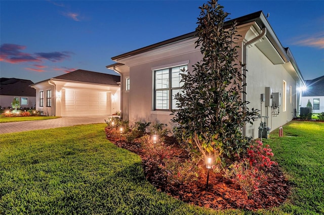 view of property exterior featuring a garage, decorative driveway, a yard, and stucco siding