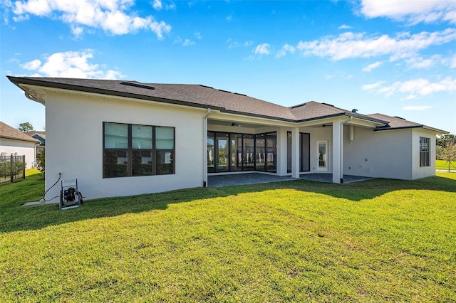 back of house with stucco siding, a lawn, ceiling fan, and a patio area