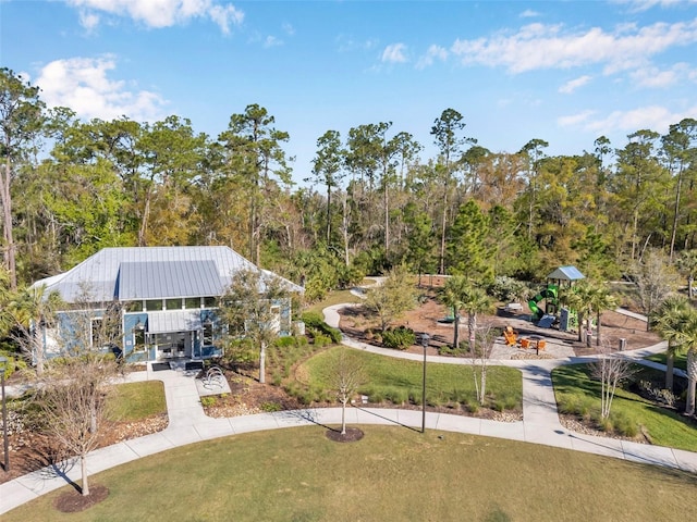 view of home's community with a view of trees and a lawn