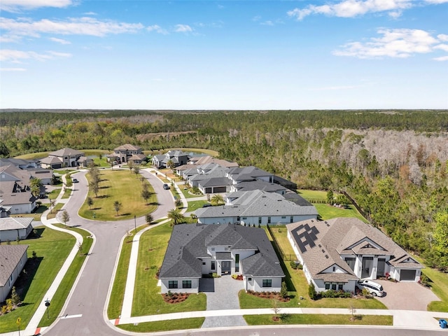 drone / aerial view with a wooded view and a residential view