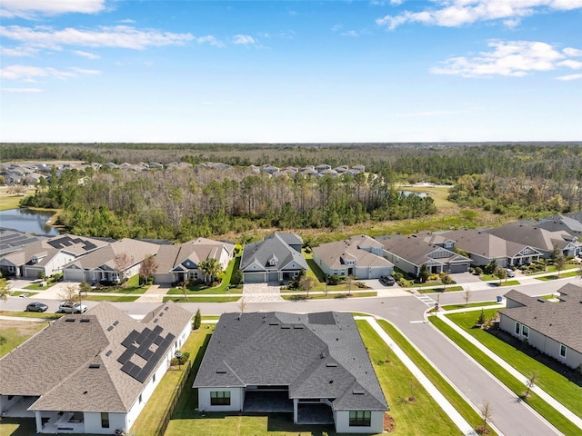 birds eye view of property featuring a residential view, a wooded view, and a water view