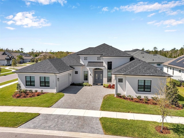 view of front of house featuring stucco siding, an attached garage, and a front lawn