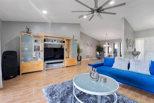 living room with wood finished floors, a ceiling fan, visible vents, baseboards, and lofted ceiling