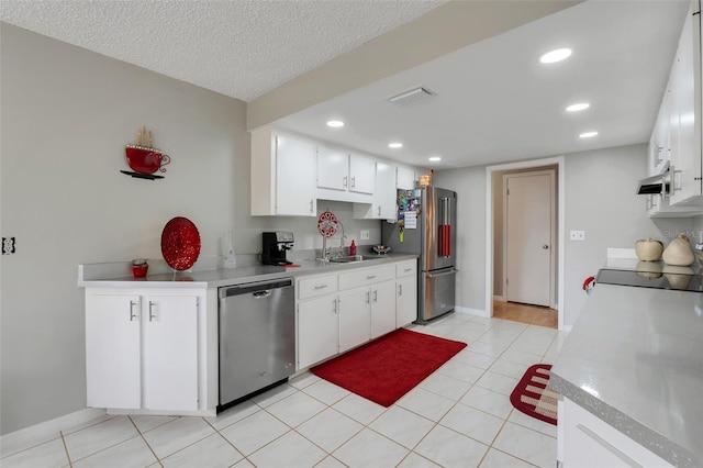 kitchen featuring visible vents, ventilation hood, light countertops, white cabinets, and stainless steel appliances