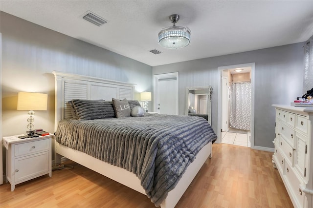 bedroom with light wood-style floors and visible vents