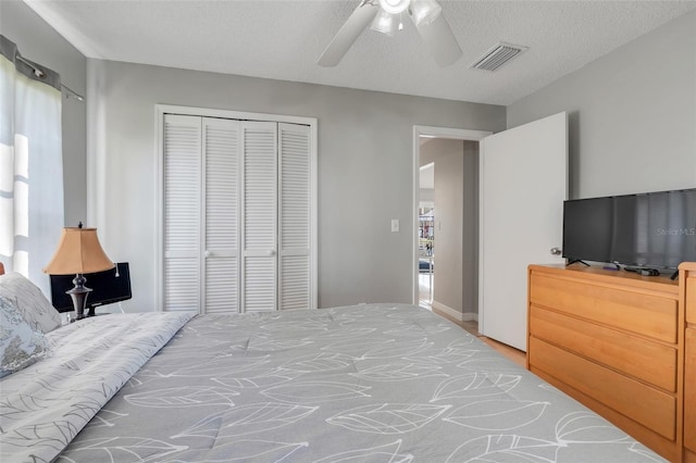 bedroom with a closet, visible vents, multiple windows, and ceiling fan