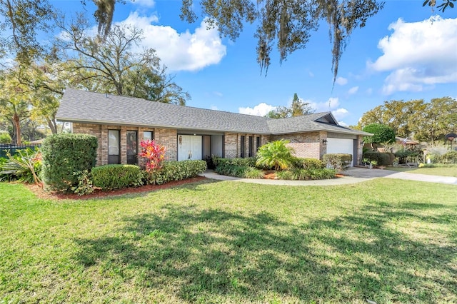 ranch-style home with concrete driveway, brick siding, a garage, and a front yard