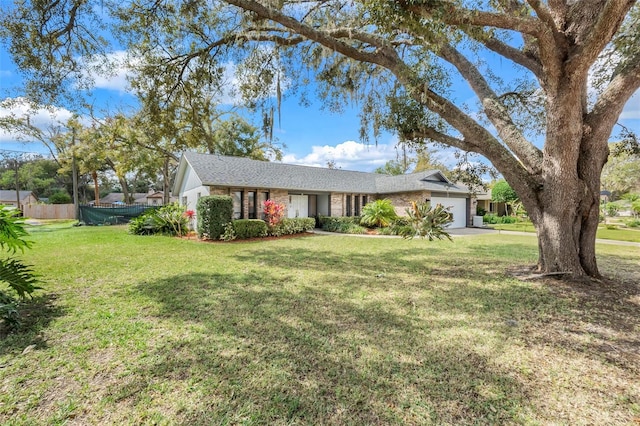 ranch-style house with a front lawn, an attached garage, and fence