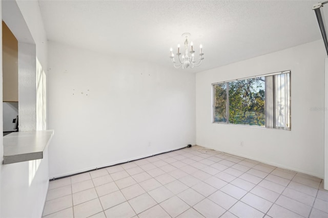 unfurnished dining area with light tile patterned flooring, a textured ceiling, and an inviting chandelier