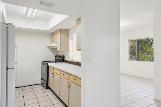 kitchen featuring visible vents, light countertops, stainless steel range with electric cooktop, freestanding refrigerator, and light tile patterned flooring