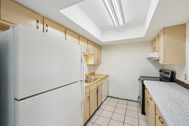 kitchen featuring under cabinet range hood, light countertops, a tray ceiling, light tile patterned floors, and white appliances