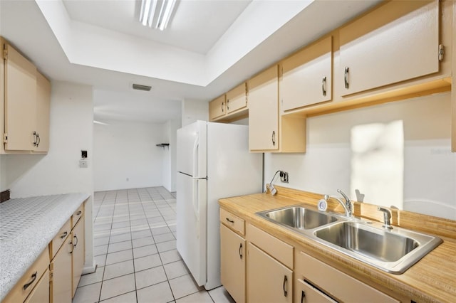 kitchen with visible vents, a sink, freestanding refrigerator, light countertops, and light tile patterned floors