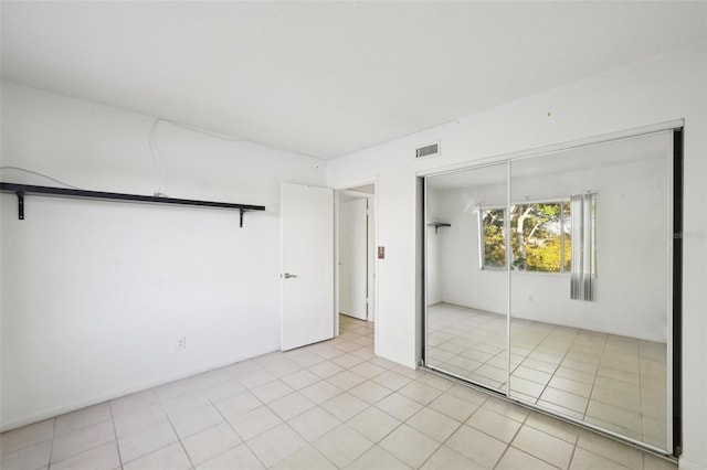 unfurnished bedroom featuring light tile patterned floors and a closet