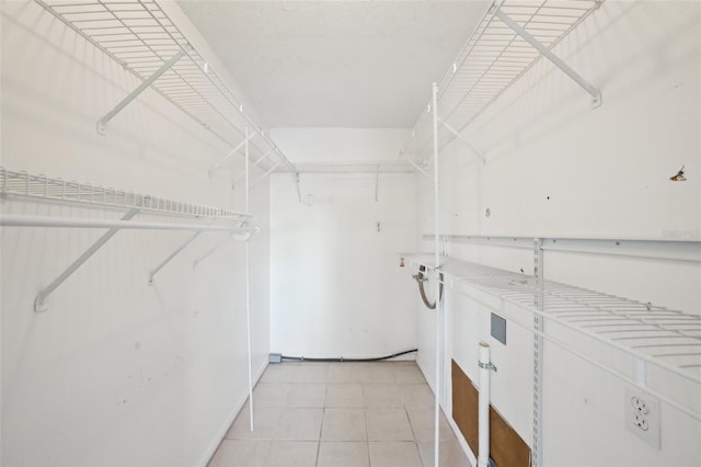 walk in closet with light tile patterned floors