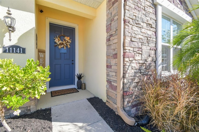 entrance to property with stone siding and stucco siding