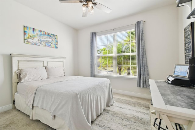 bedroom with light colored carpet, a ceiling fan, and baseboards