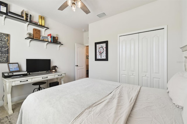 carpeted bedroom featuring a closet, visible vents, baseboards, and a ceiling fan