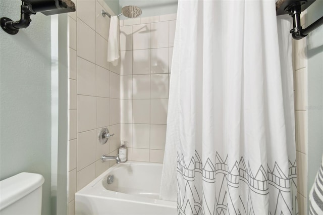 bathroom featuring shower / tub combo and toilet