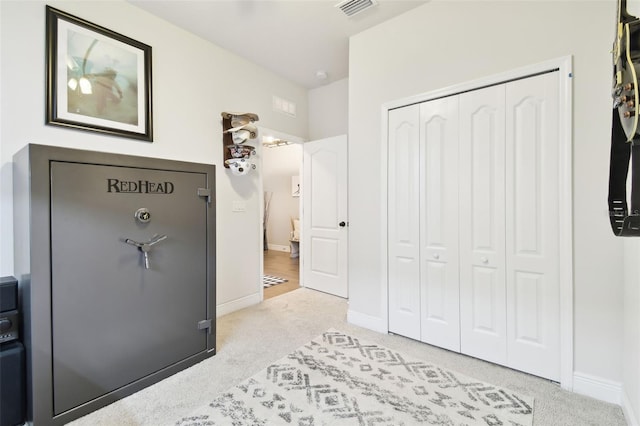 carpeted bedroom with visible vents, baseboards, and a closet