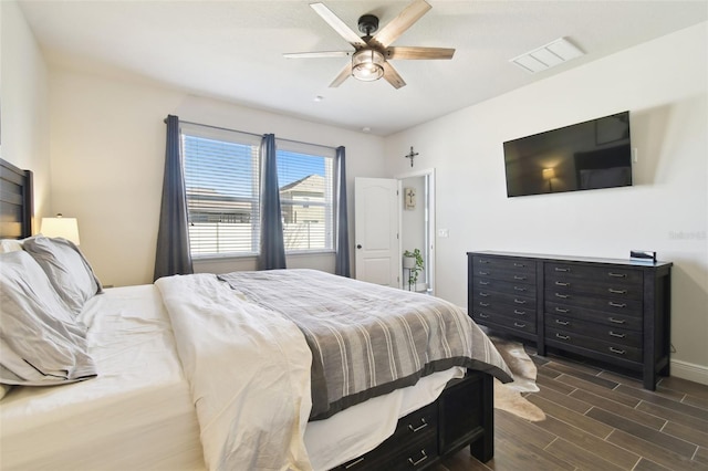 bedroom featuring wood finish floors, visible vents, baseboards, and a ceiling fan