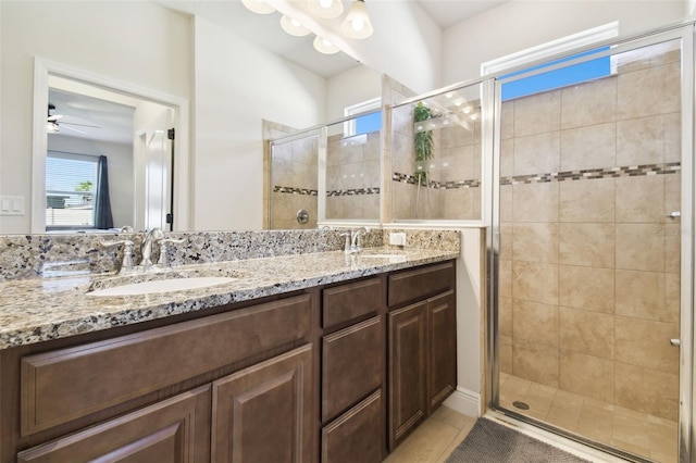 full bathroom with a sink, a stall shower, double vanity, and tile patterned flooring