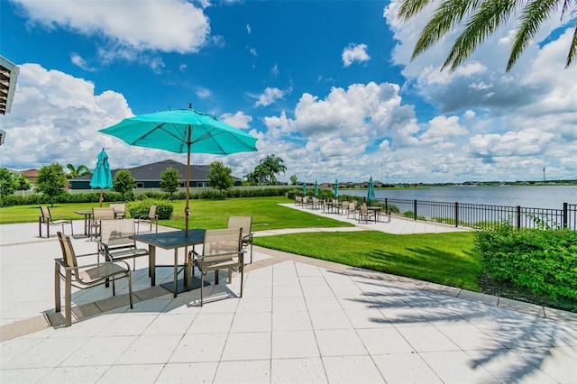 view of patio / terrace featuring fence and a water view