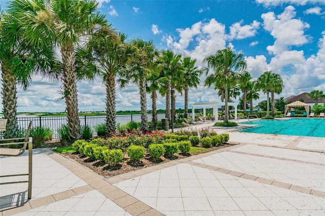 community pool featuring a patio, fence, a water view, and a pergola