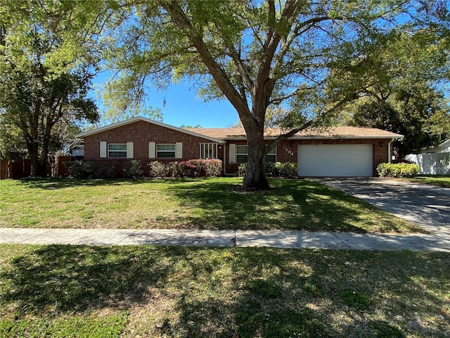 single story home with brick siding, a front lawn, fence, concrete driveway, and a garage