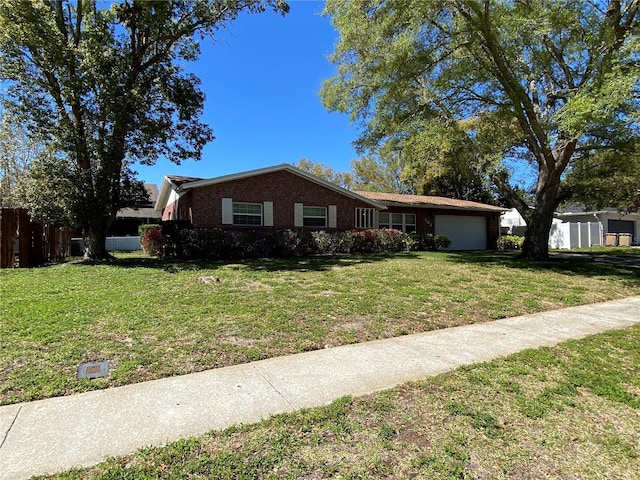 ranch-style home with a garage, brick siding, a front lawn, and fence