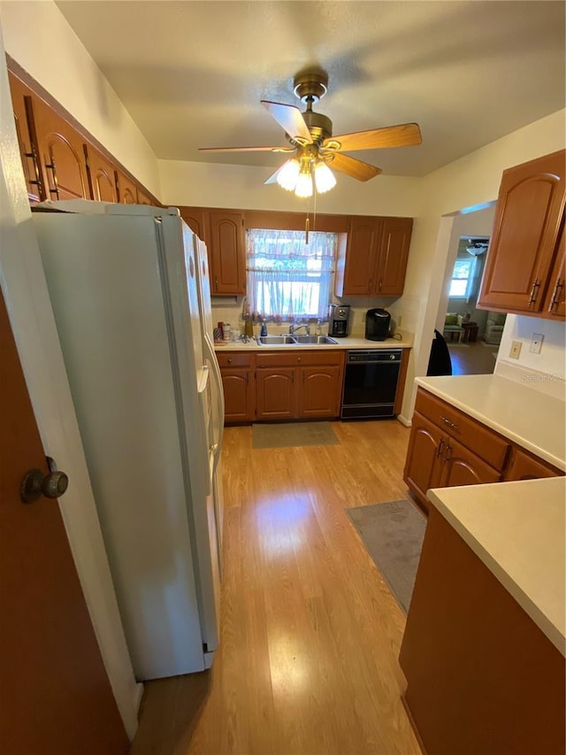 kitchen with a ceiling fan, freestanding refrigerator, a sink, dishwasher, and light wood-type flooring