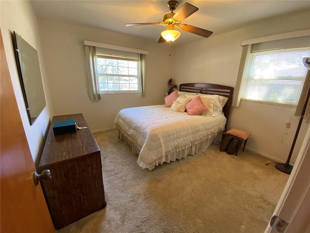 carpeted bedroom with a ceiling fan and baseboards