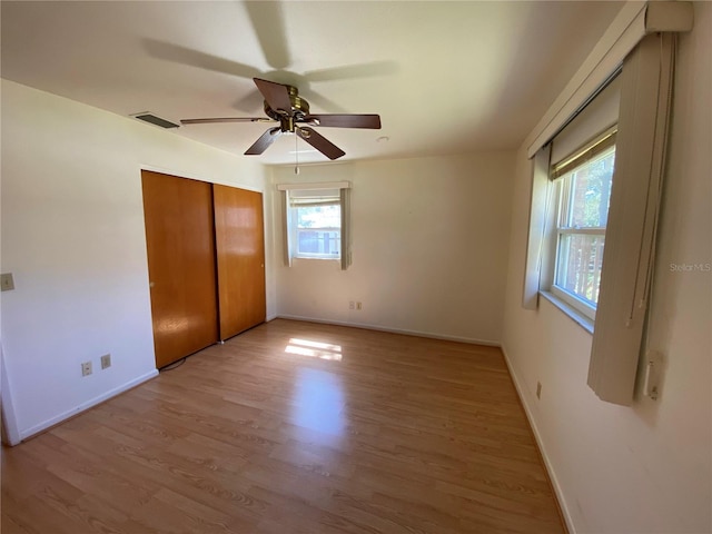 unfurnished bedroom featuring a closet, visible vents, light wood-type flooring, and baseboards